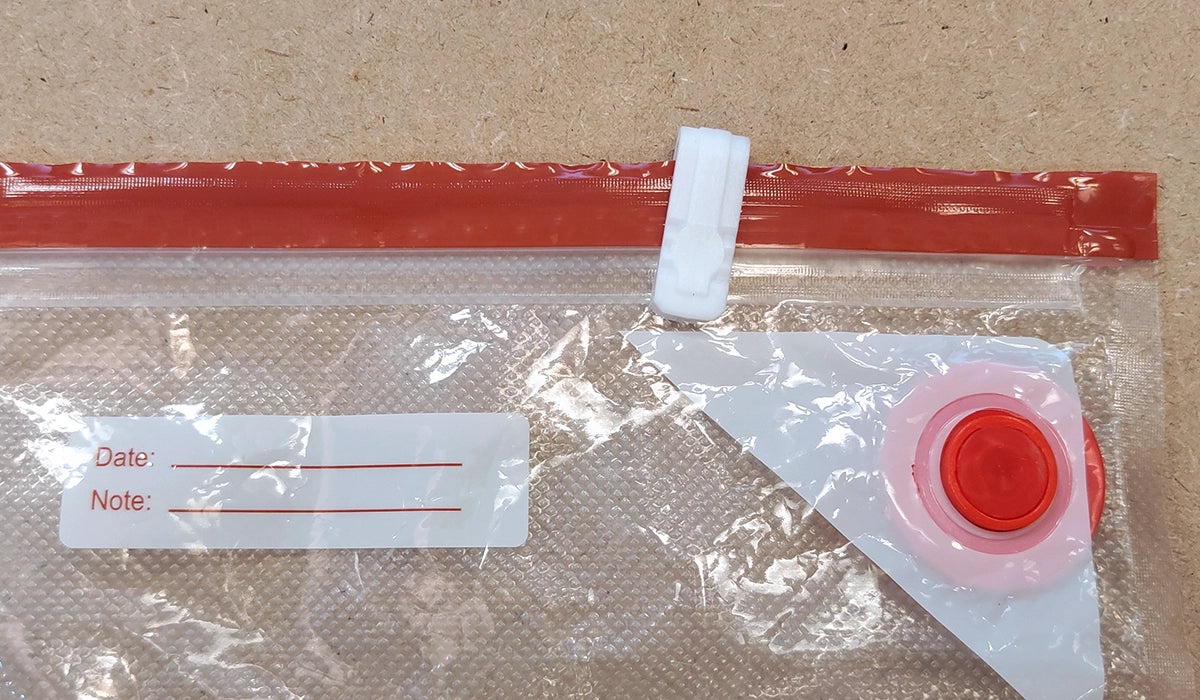 Slider closing the double zipper on a vacuum bag